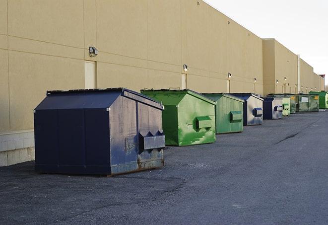 a compact construction dumpster being emptied by a waste disposal truck in Abrams, WI